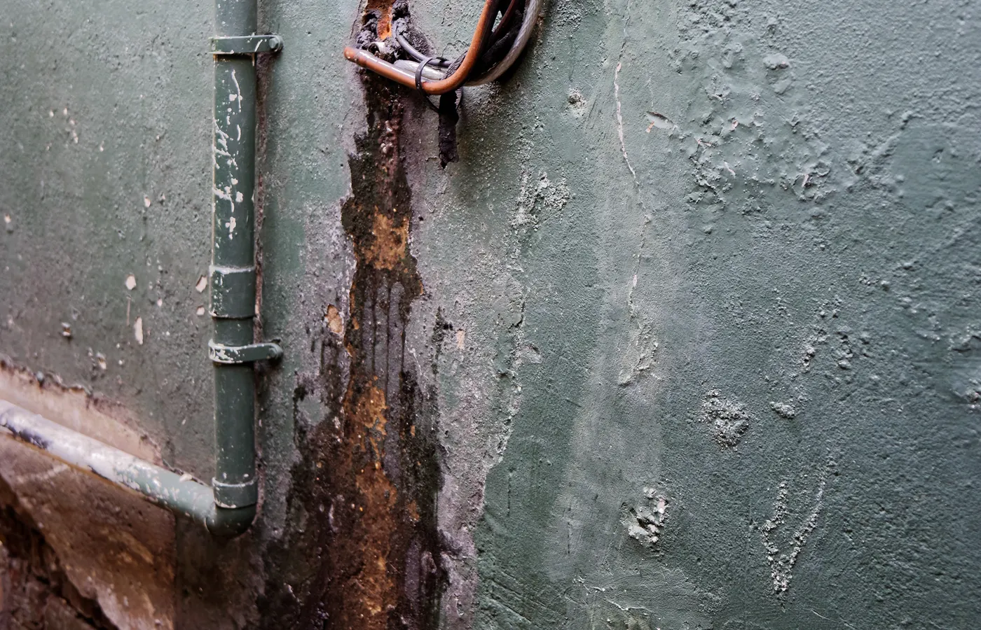Peeling paint and staining on a wall affected by persistent water damage
